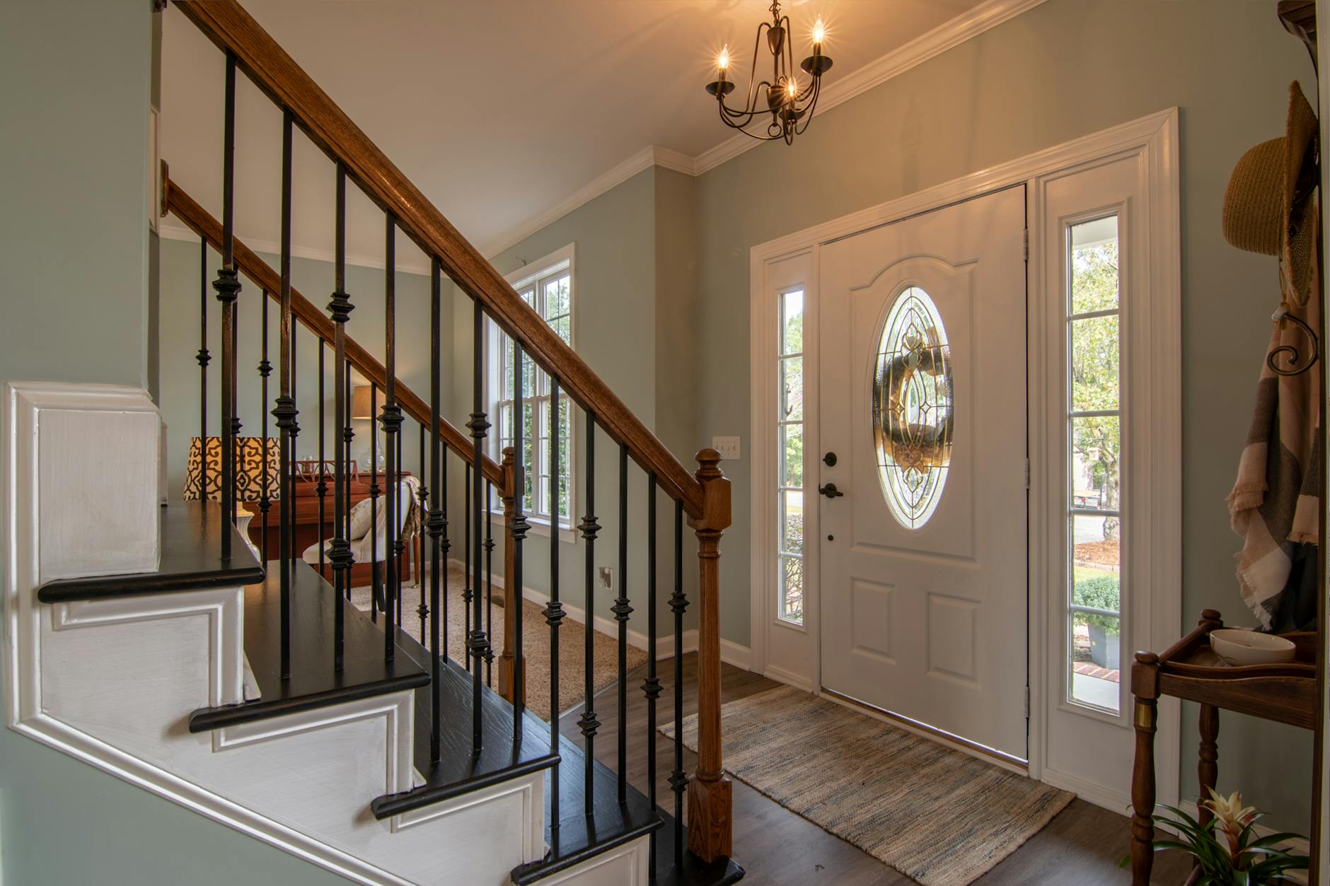 brown wooden staircase with brass chandelier